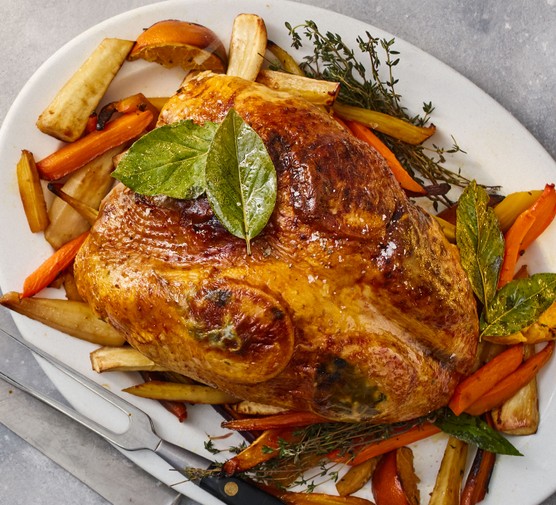 Healthy-roast-turkey-crown Roast turkey crown on a plate with roast carrots, parsnips and thyme