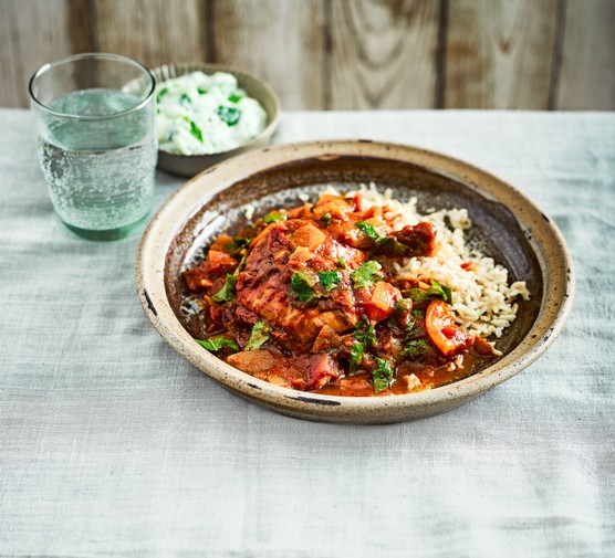 Slow cooker recipes Bowl of chicken curry and rice next to a bowl of yoghurt and glass of water